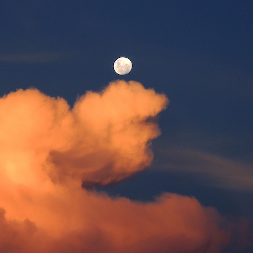 A meditative scene of the full moon and clouds.